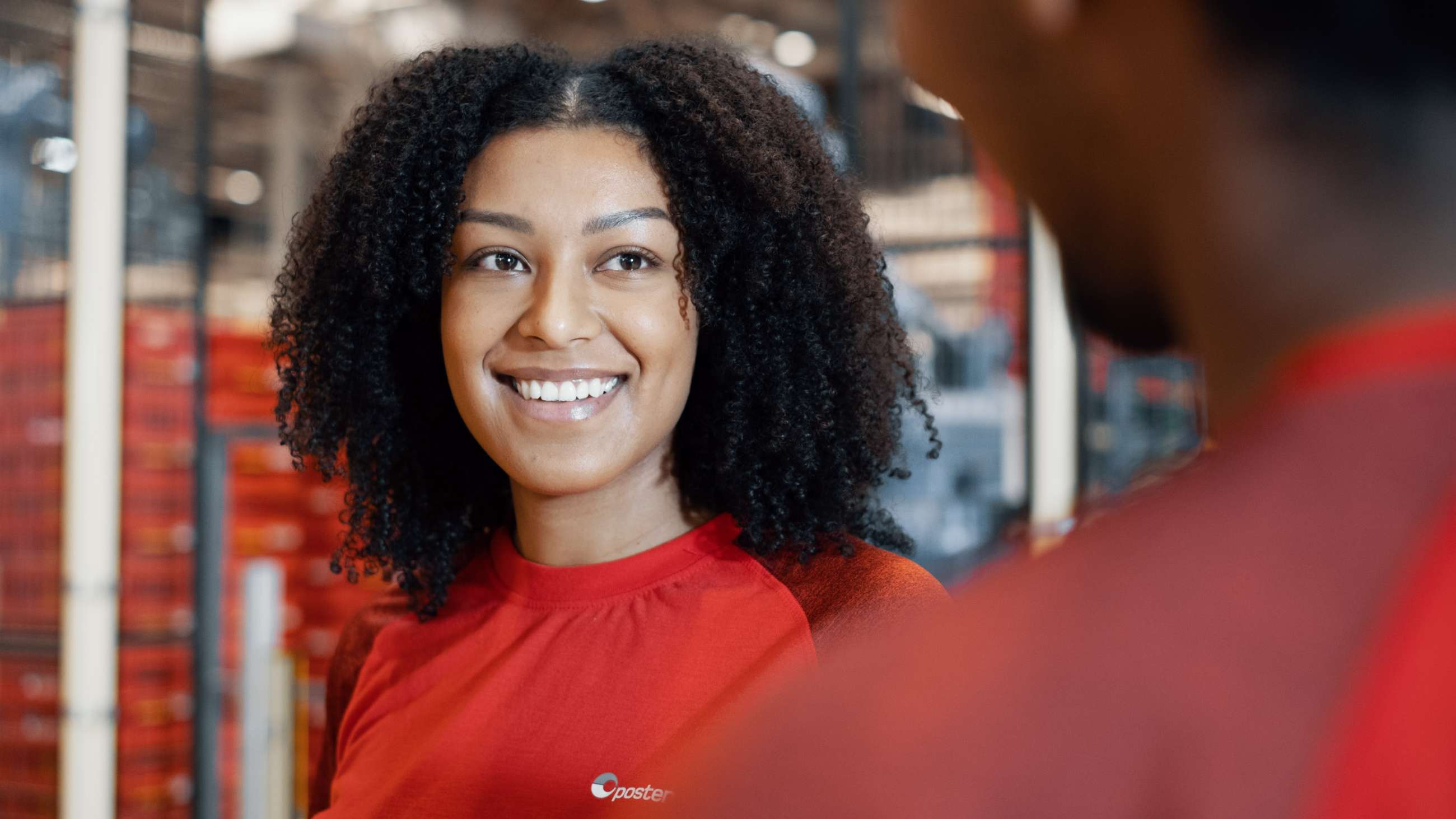 Posten-ansatt smiler til kollega