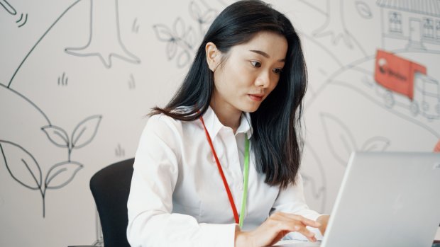 Kvinnelig ansatt i Posten Norge AS jobber på PC