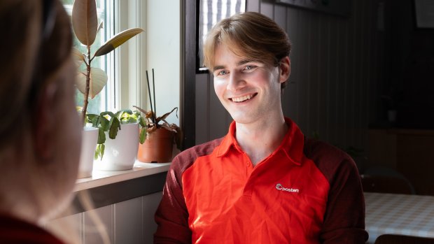 Ung sjåfør fra Posten i samtale med en kunde